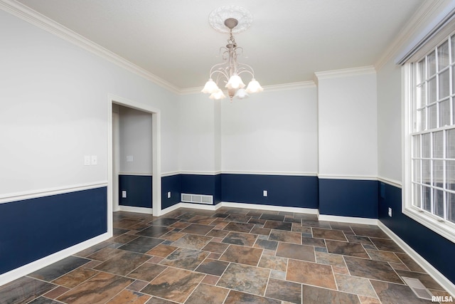 6800 Ridges Ct, Bettendorf, IA 52722 - spare room featuring a chandelier, stone finish flooring, ornamental molding, and baseboards
