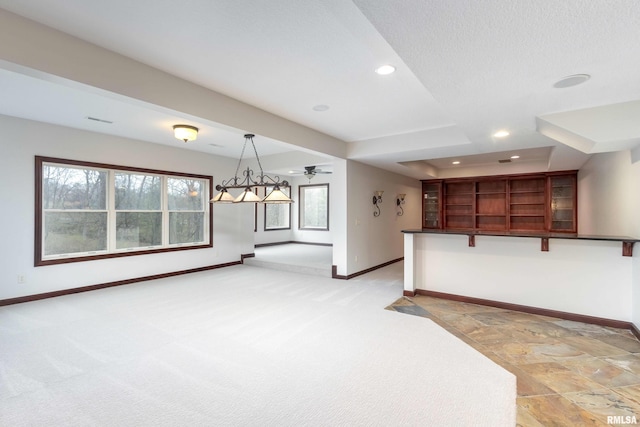 6800 Ridges Ct, Bettendorf, IA 52722 - unfurnished living room with baseboards, recessed lighting, light colored carpet, light stone finish floors, and ceiling fan