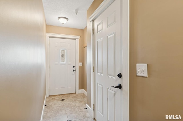 725 Cox Ct, Le Claire, IA 52753 - entryway featuring baseboards, light tile patterned floors, and a textured ceiling