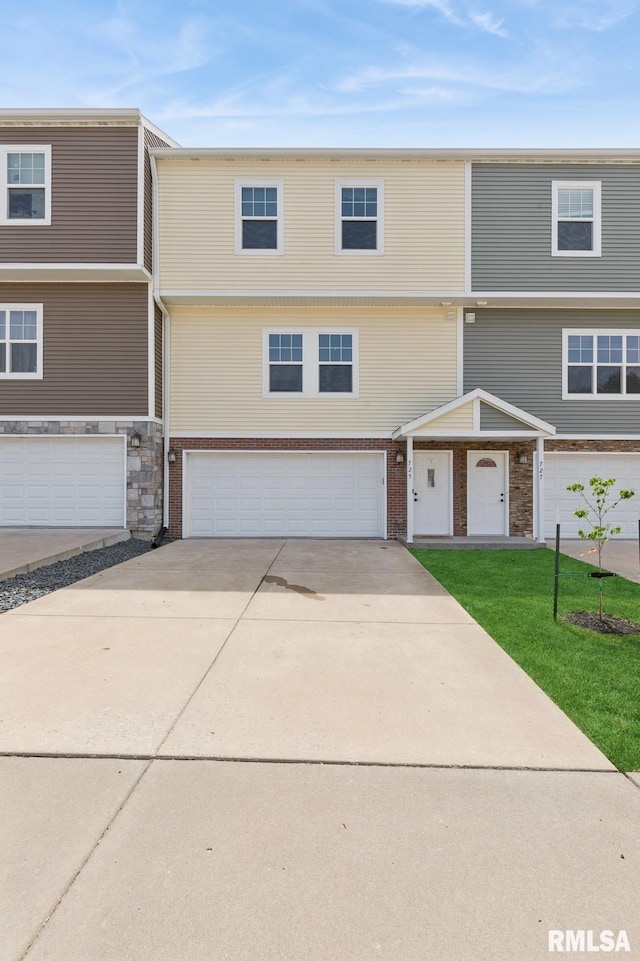 725 Cox Ct, Le Claire, IA 52753 - multi unit property featuring driveway, an attached garage, and a front yard