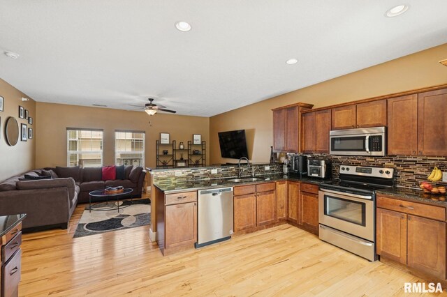 725 Cox Ct, Le Claire, IA 52753 - kitchen featuring stainless steel appliances, open floor plan, decorative backsplash, brown cabinetry, and recessed lighting