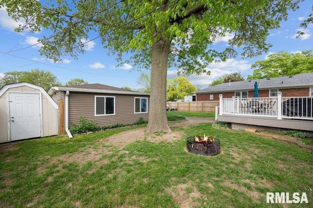 3430 W Locust St, Davenport, IA 52804 - view of yard featuring an outdoor fire pit, a deck, an outdoor structure, and a storage shed