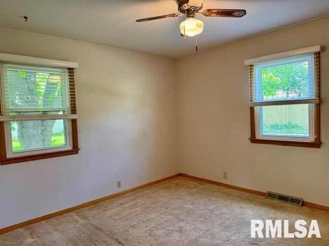 1003 16th Ave N, Clinton, IA 52732 - spare room with ceiling fan, baseboards, and light colored carpet