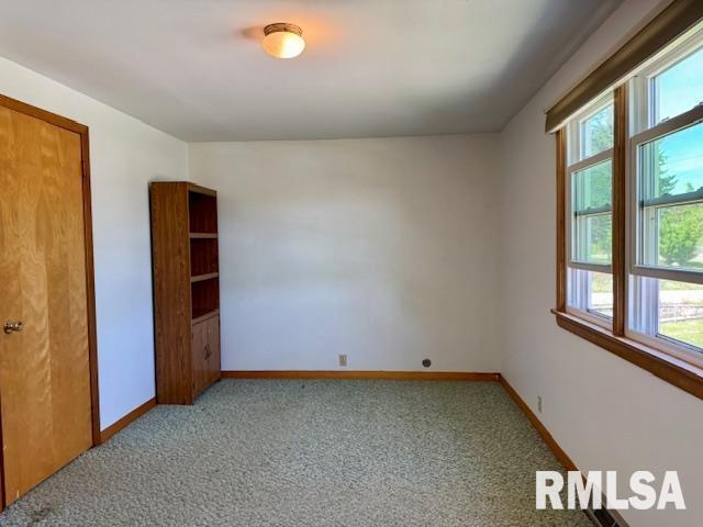 1003 16th Ave N, Clinton, IA 52732 - unfurnished room with light carpet and baseboards