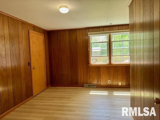 1003 16th Ave N, Clinton, IA 52732 - empty room with light wood finished floors and wooden walls