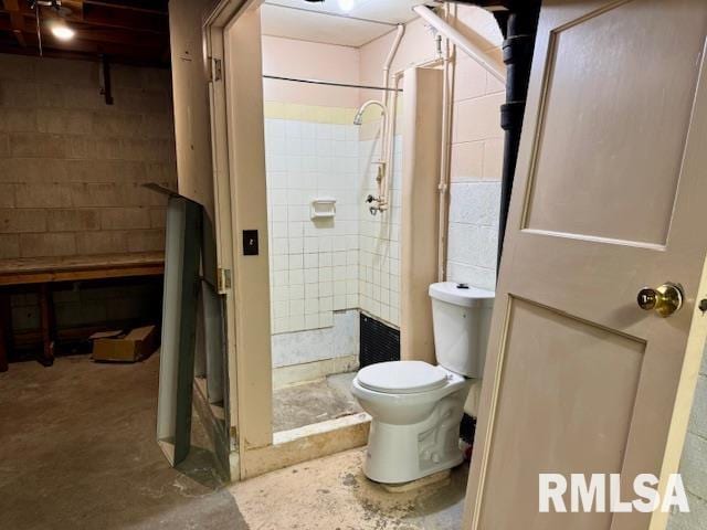 1003 16th Ave N, Clinton, IA 52732 - bathroom with a stall shower, unfinished concrete flooring, toilet, and concrete block wall