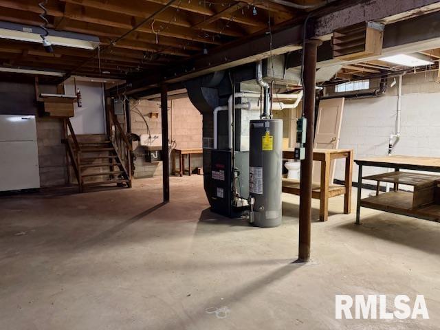 1003 16th Ave N, Clinton, IA 52732 - unfinished below grade area featuring electric water heater, fridge, heating unit, and stairs