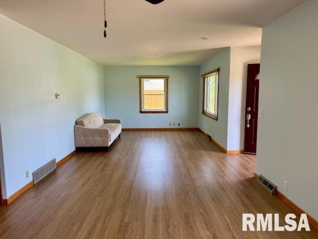 1003 16th Ave N, Clinton, IA 52732 - living area featuring baseboards and wood finished floors