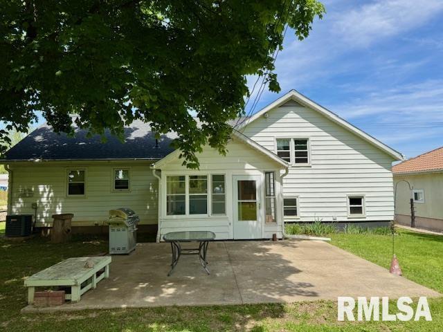 1003 16th Ave N, Clinton, IA 52732 - back of house with a patio, central AC unit, and a yard