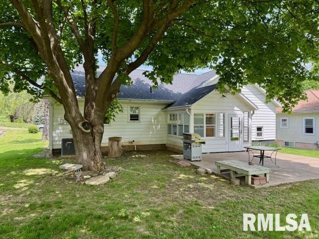 1003 16th Ave N, Clinton, IA 52732 - rear view of property with a patio area, a lawn, and roof with shingles