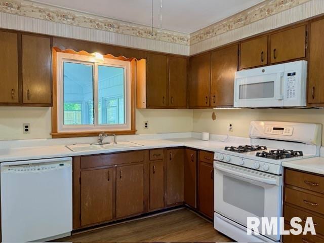 1003 16th Ave N, Clinton, IA 52732 - kitchen with white appliances, wallpapered walls, a sink, light countertops, and wood finished floors
