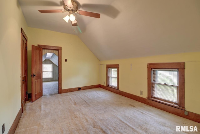 1845 S Bluff Blvd, Clinton, IA 52732 - spare room featuring light carpet, vaulted ceiling, a ceiling fan, and baseboards