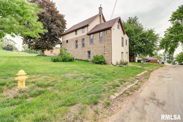 1845 S Bluff Blvd, Clinton, IA 52732 - view of side of home with stone siding, a yard, and a chimney