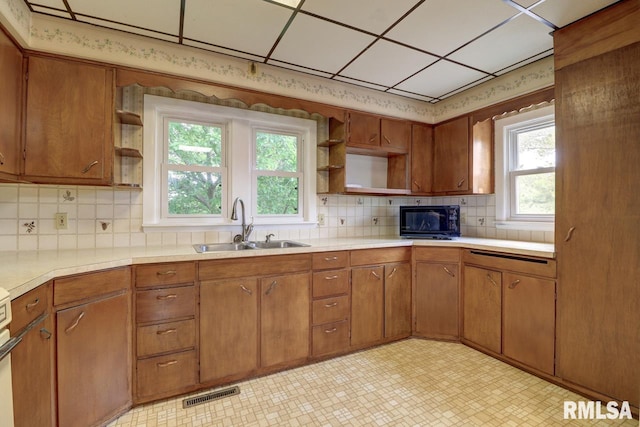 1845 S Bluff Blvd, Clinton, IA 52732 - kitchen with open shelves, black microwave, a sink, and light countertops