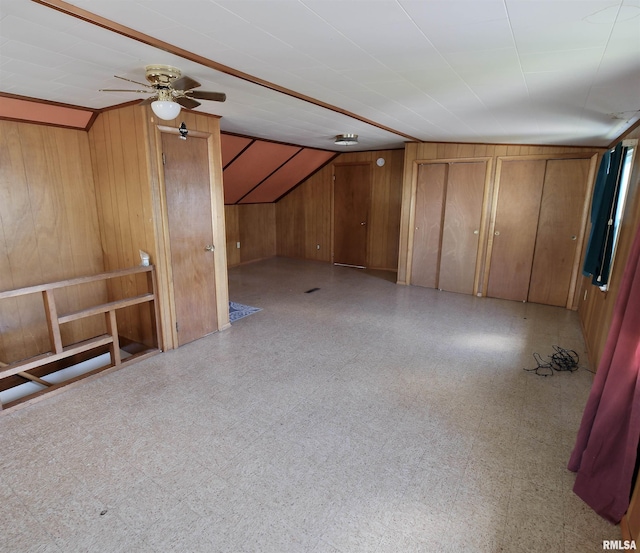 bonus room featuring wood walls, tile patterned floors, ceiling fan, and lofted ceiling
