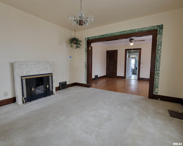 unfurnished living room with carpet, baseboards, a fireplace, and a chandelier