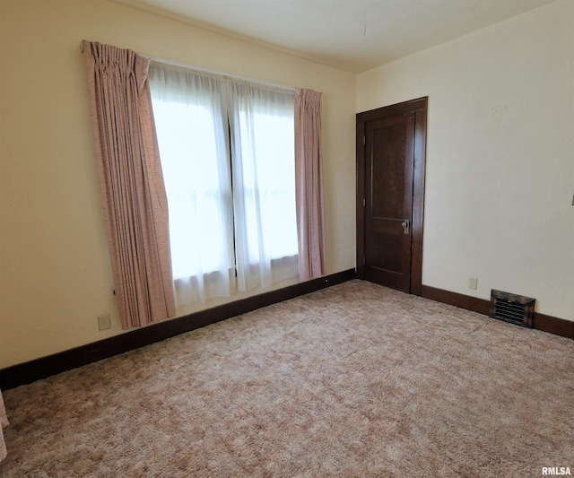 empty room featuring carpet and baseboards