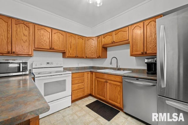 kitchen with appliances with stainless steel finishes, a sink, brown cabinets, dark countertops, and crown molding