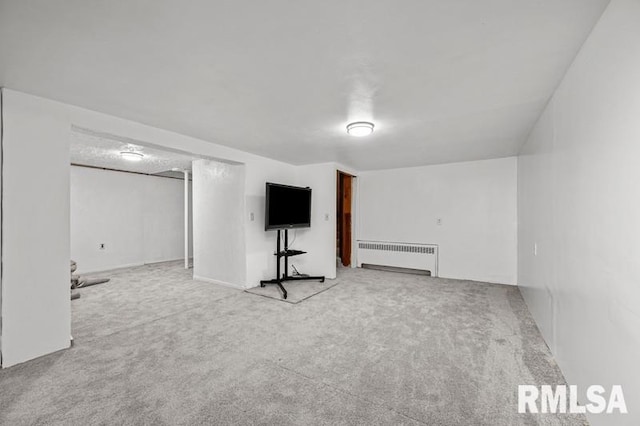 finished below grade area featuring radiator heating unit and carpet floors