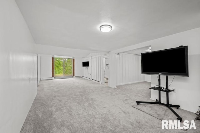 unfurnished living room with carpet flooring and a baseboard heating unit
