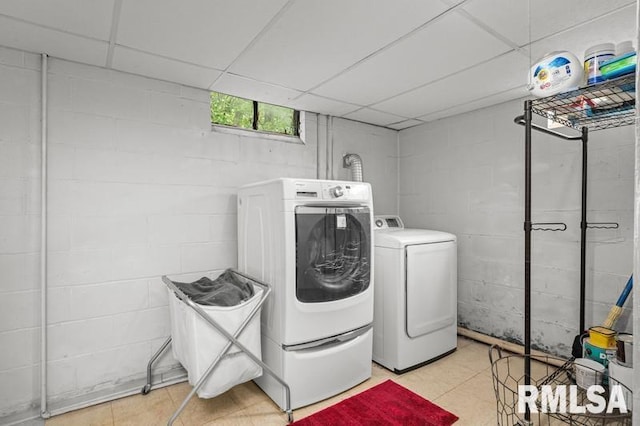washroom with washing machine and clothes dryer and light tile patterned floors