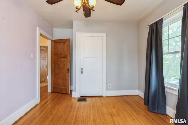 2505 Iowa St, Davenport, IA 52803 - unfurnished bedroom featuring baseboards, light wood-style flooring, and a ceiling fan