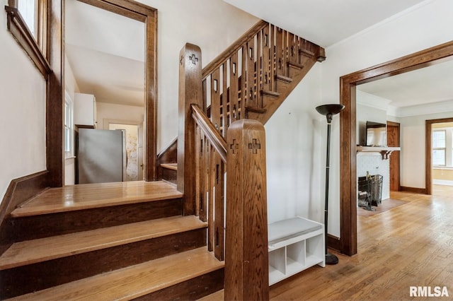 2505 Iowa St, Davenport, IA 52803 - staircase featuring crown molding, wood finished floors, baseboards, and a fireplace with flush hearth