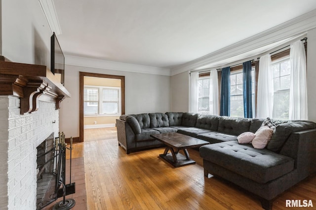 2505 Iowa St, Davenport, IA 52803 - living area featuring plenty of natural light, light wood finished floors, a brick fireplace, crown molding, and baseboards