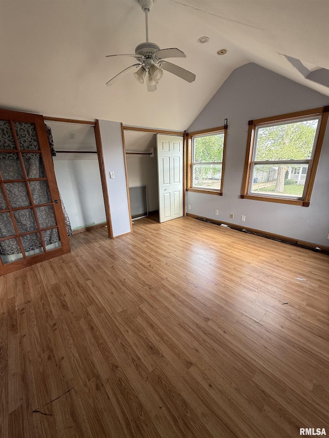 237 1st Ave, Clinton, IA 52732 - unfurnished bedroom featuring multiple closets, wood finished floors, vaulted ceiling, and baseboards