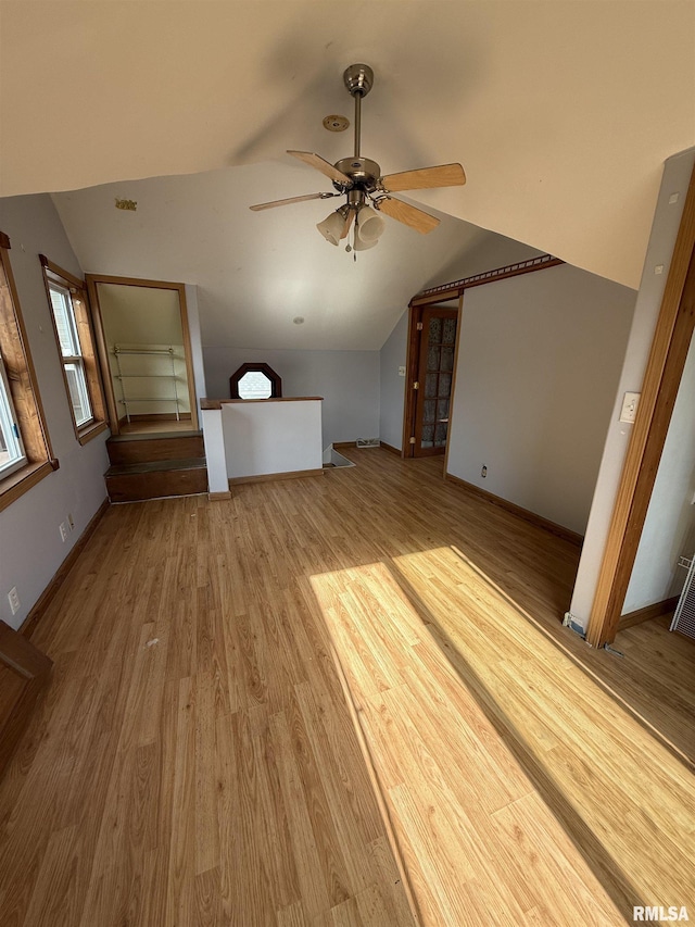 237 1st Ave, Clinton, IA 52732 - unfurnished living room with lofted ceiling, wood finished floors, a ceiling fan, and baseboards