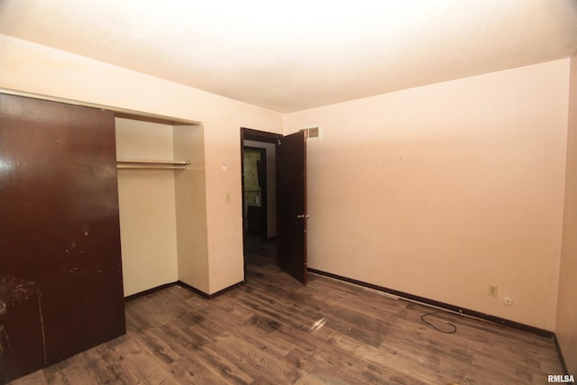 2630 N Concord St, Davenport, IA 52804 - unfurnished bedroom with wood finished floors, baseboards, and a closet