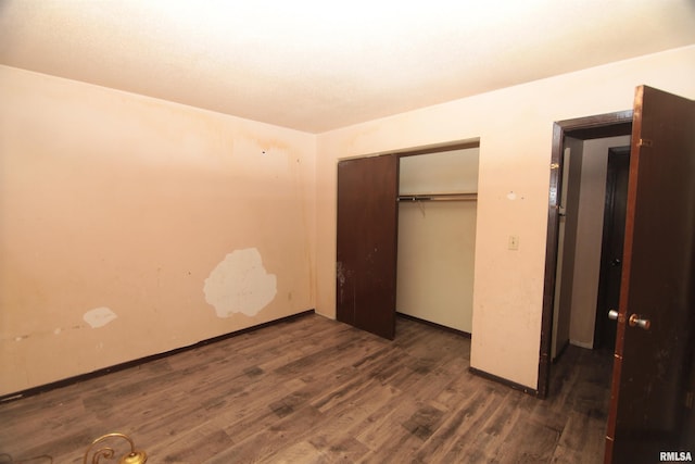 2630 N Concord St, Davenport, IA 52804 - unfurnished bedroom featuring dark wood-type flooring, a closet, and baseboards