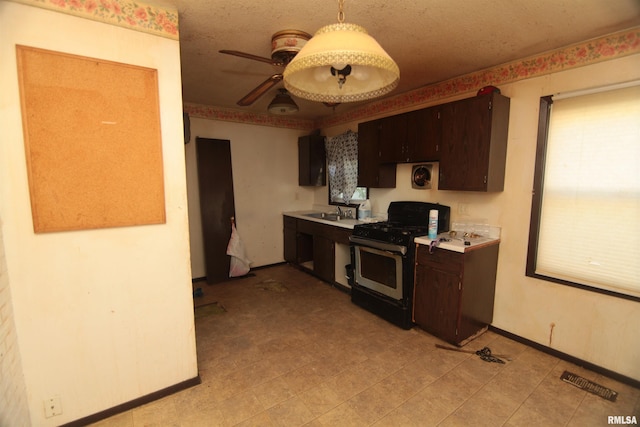 2630 N Concord St, Davenport, IA 52804 - kitchen featuring stainless steel gas stove, dark brown cabinetry, light countertops, and a ceiling fan