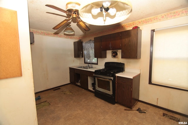 2630 N Concord St, Davenport, IA 52804 - kitchen with gas stove, ceiling fan, light countertops, dark brown cabinetry, and a sink