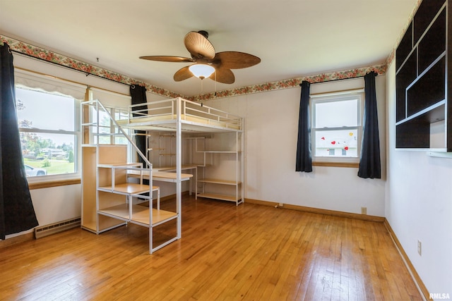 bedroom featuring light wood-style floors, baseboards, and multiple windows