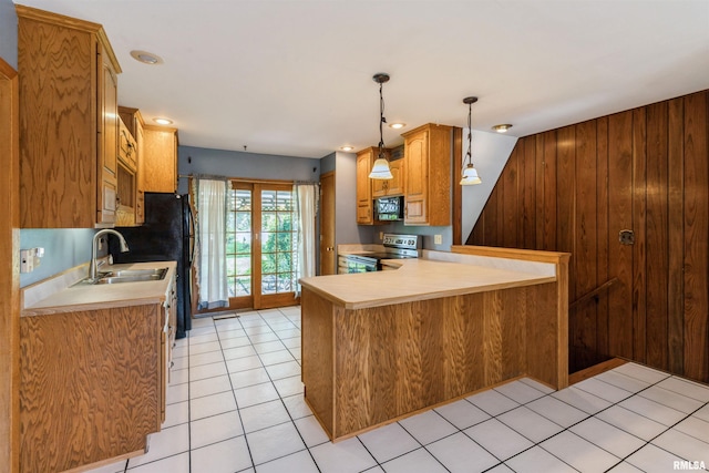 kitchen featuring stainless steel electric range, black microwave, a sink, light countertops, and a peninsula