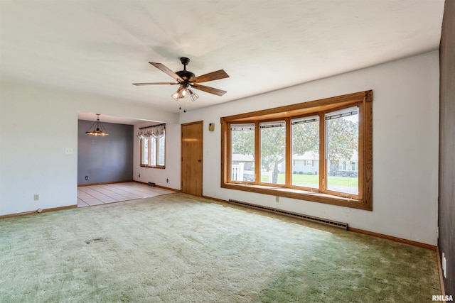 carpeted spare room with baseboard heating, baseboards, and a ceiling fan