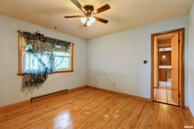 empty room featuring a baseboard radiator, light wood-style floors, ceiling fan, and baseboards