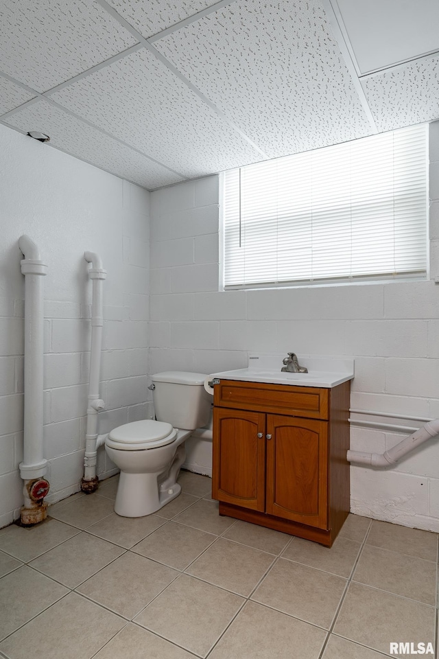 2845 Washington Ln, Davenport, IA 52804 - bathroom with tile patterned flooring, a drop ceiling, toilet, a sink, and concrete block wall