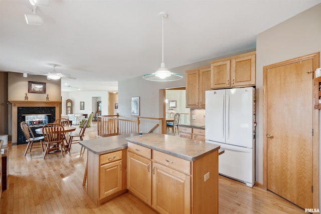 23835 284th Ave, Le Claire, IA 52748 - kitchen featuring freestanding refrigerator, light brown cabinets, ceiling fan, a kitchen island, and light wood finished floors