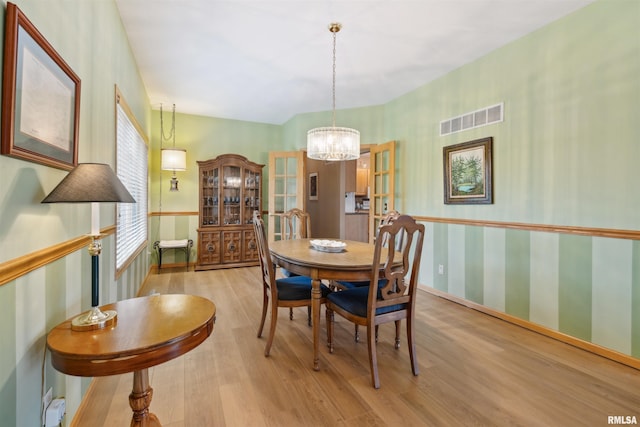 23835 284th Ave, Le Claire, IA 52748 - dining space featuring wood finished floors, a chandelier, and baseboards