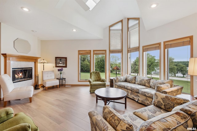 23835 284th Ave, Le Claire, IA 52748 - living area with a tiled fireplace, light wood-style floors, recessed lighting, baseboards, and high vaulted ceiling