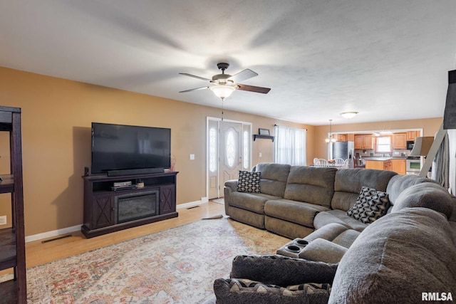 324 N Broadway, Goreville, IL 62939 - living area featuring baseboards, ceiling fan, and light wood-style flooring