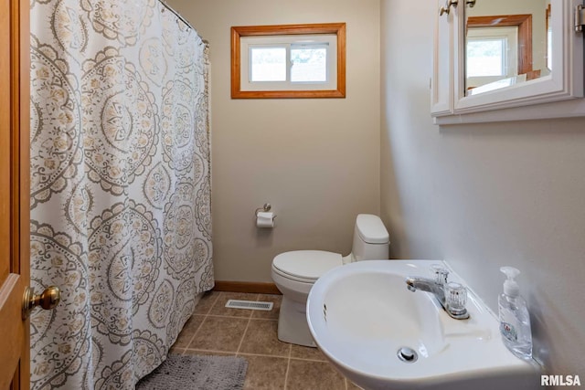 324 N Broadway, Goreville, IL 62939 - bathroom with a sink, tile patterned flooring, toilet, baseboards, and curtained shower