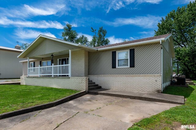 324 N Broadway, Goreville, IL 62939 - ranch-style house with a porch, a front lawn, and brick siding