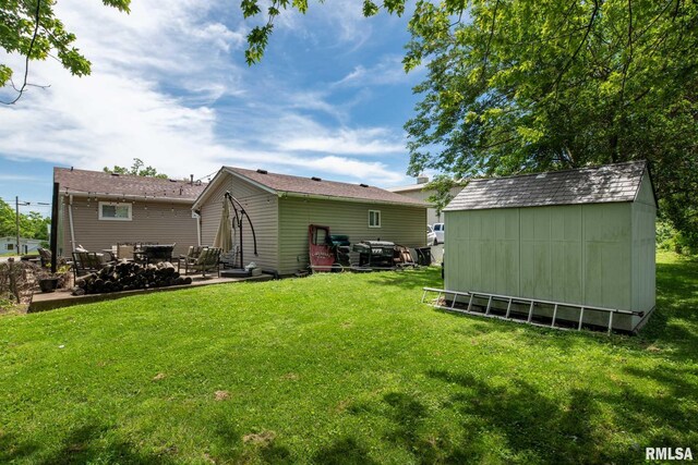 324 N Broadway, Goreville, IL 62939 - back of property with a storage unit, a patio, an outbuilding, and a lawn