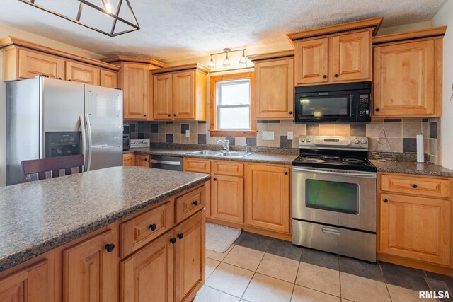 324 N Broadway, Goreville, IL 62939 - kitchen with appliances with stainless steel finishes, a sink, dark countertops, tasteful backsplash, and a textured ceiling