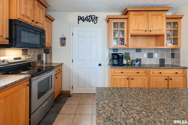 324 N Broadway, Goreville, IL 62939 - kitchen with stainless steel range with electric stovetop, black microwave, decorative backsplash, glass insert cabinets, and a textured ceiling