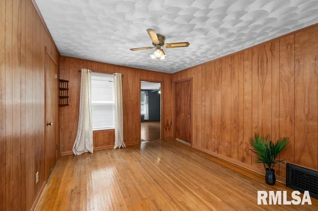 824 S State St, Geneseo, IL 61254 - empty room with ceiling fan, hardwood / wood-style floors, wood walls, and baseboards