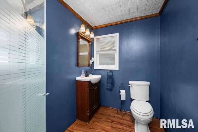 824 S State St, Geneseo, IL 61254 - bathroom featuring wood finished floors, toilet, ornamental molding, and vanity